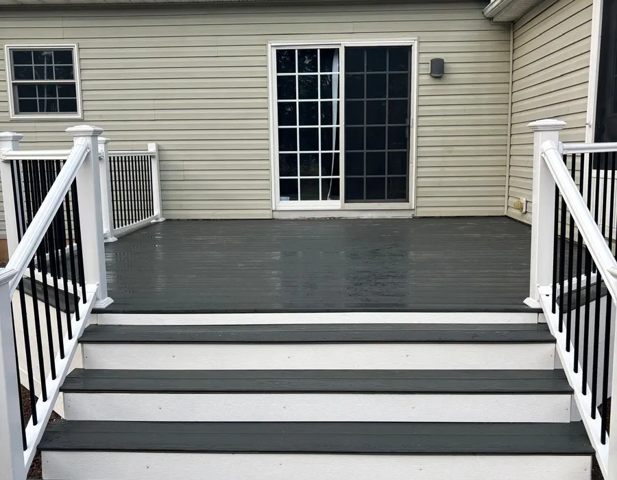 Composite deck entrance with white railings, black balusters and wide stairs