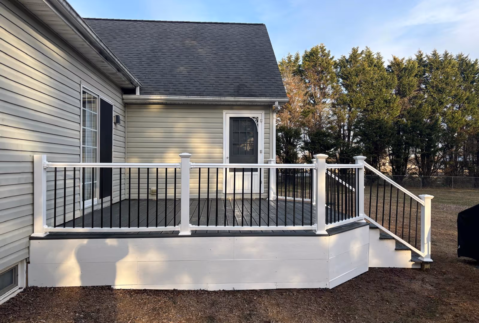 Finished composite deck with white posts, black balusters and side stairs