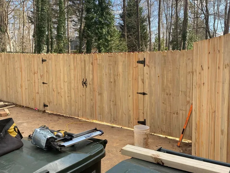 Wood privacy fence with two custom access gates and black hardware