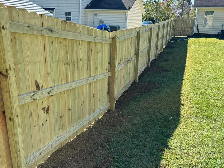 Completed wood privacy fence enclosing a residential backyard