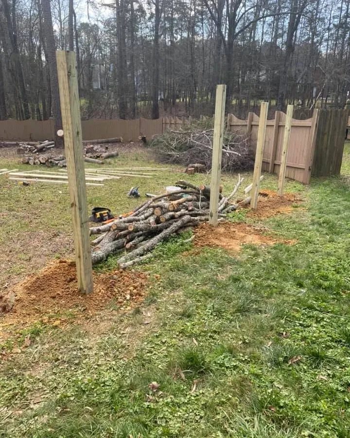 Wood fence posts being installed around a backyard